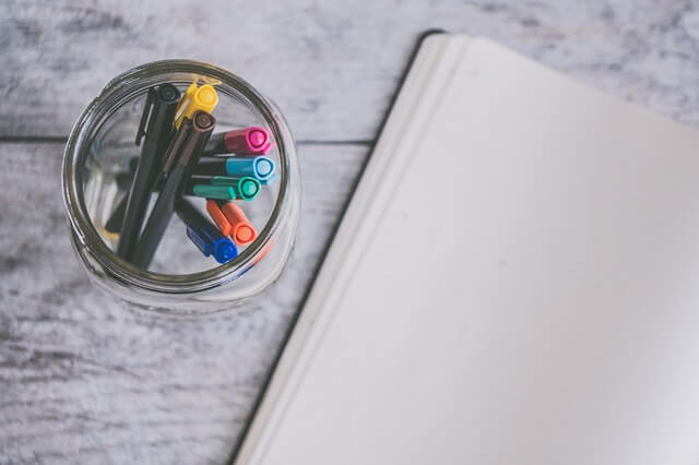 Pens and paper getting ready to create a bullet journal setup.