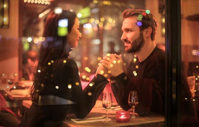 The best winter date idea. Two partners at a restaurant eating dinner.