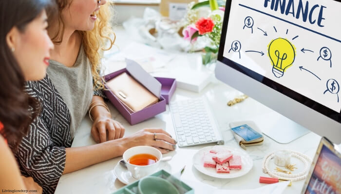 Two girls planning out a list of financial goals on their computer.