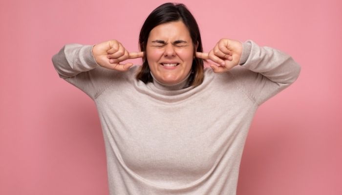 girl avoiding money blocks by plugging her ears